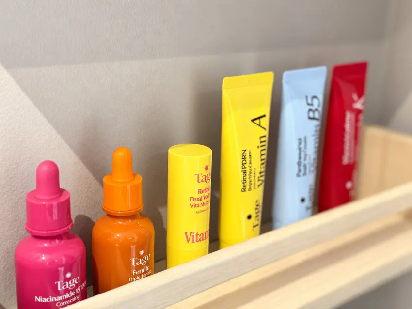 Tage Vita serums, retinal stick and creams in pink, orange, yellow, blue and red packaging lined up on a bathroom shelf