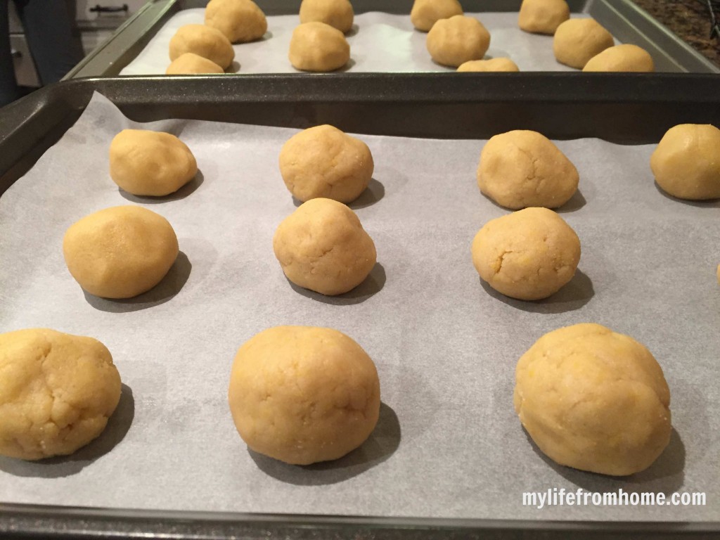 Vanilla scone cookie dough balls spaced out on parchment lined baking trays before baking