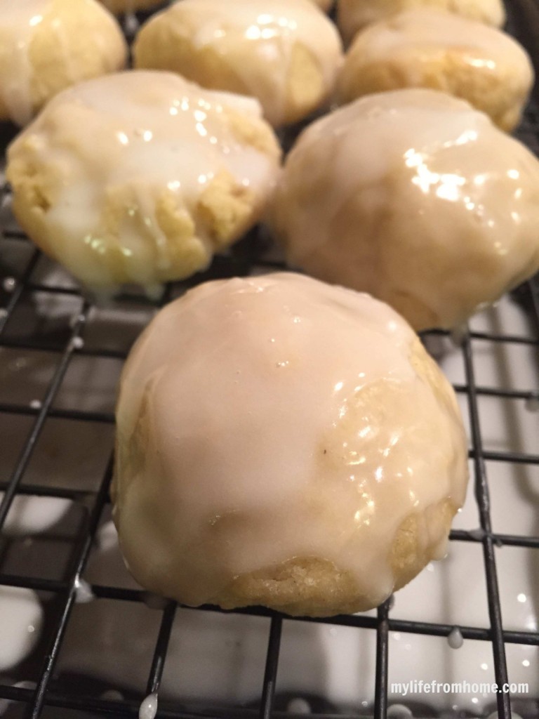 Close up of glazed vanilla scone cookies on a wire cooling rack showing the smooth glossy glaze