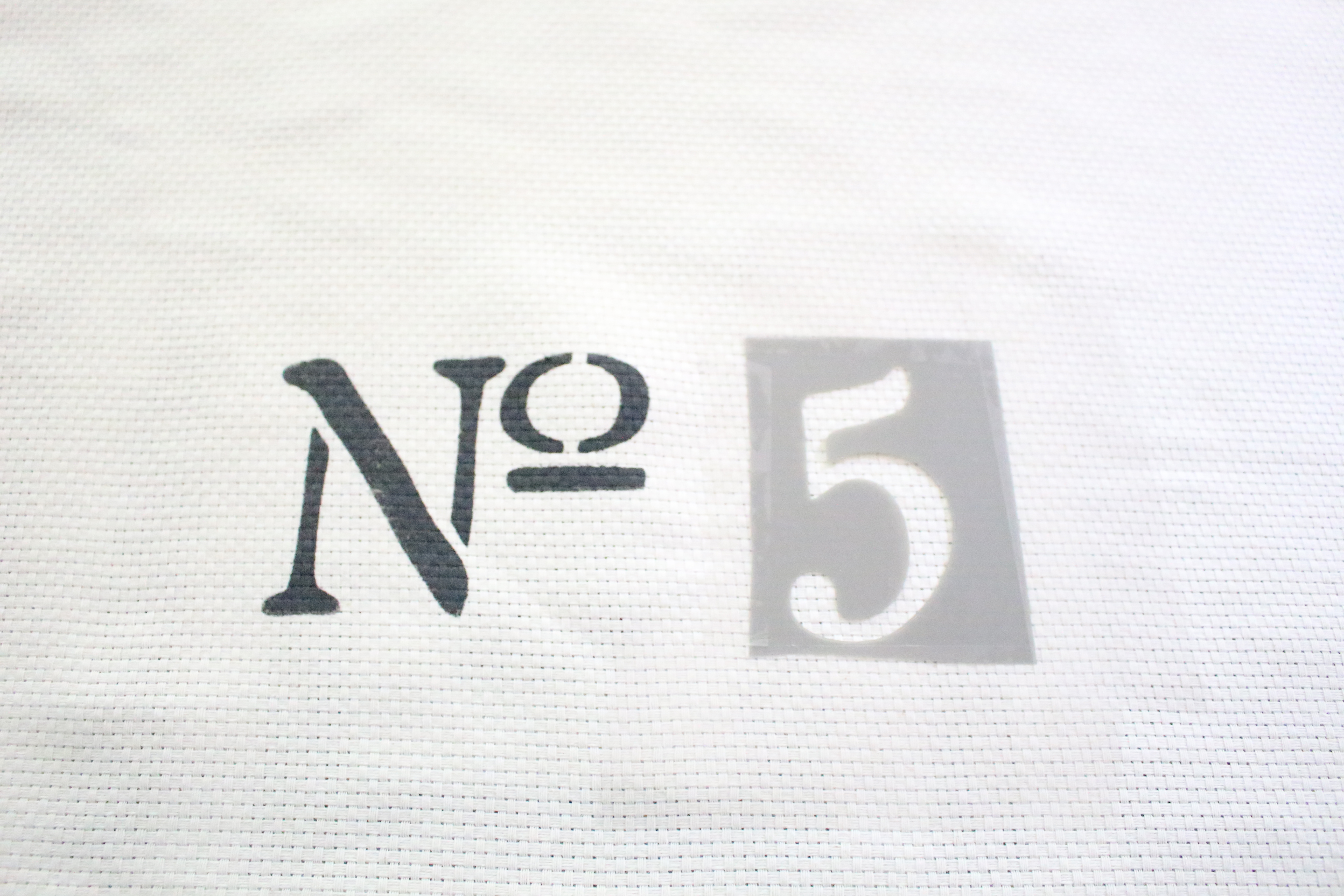 No. 5 Stencil on a Farmhouse Pillow Cover Project by www.whitecottagehomeandliving.com