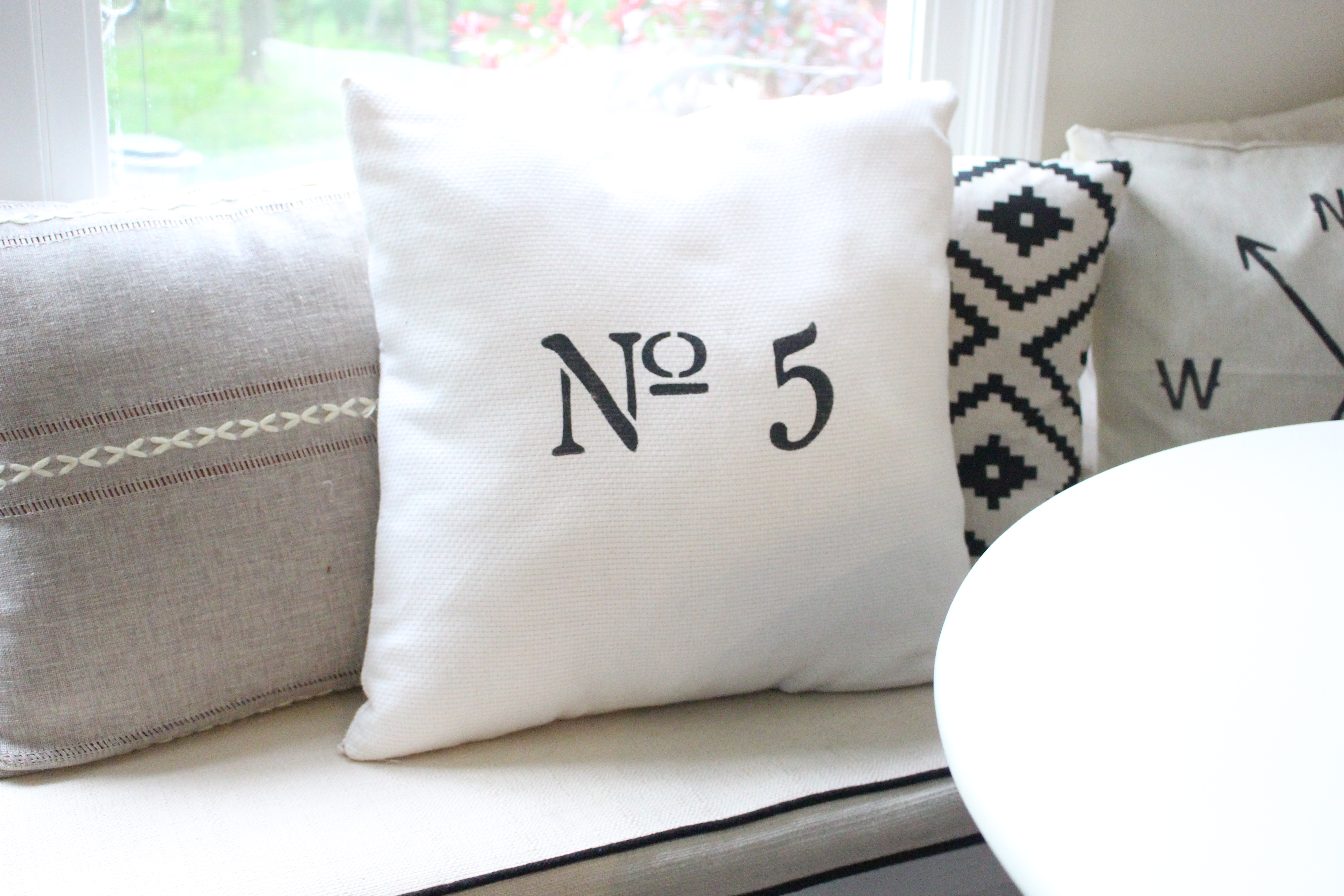 Finished Number Pillow Using a Stencil and Black Fabric Paint by www.whitecottagehomeandliving.com