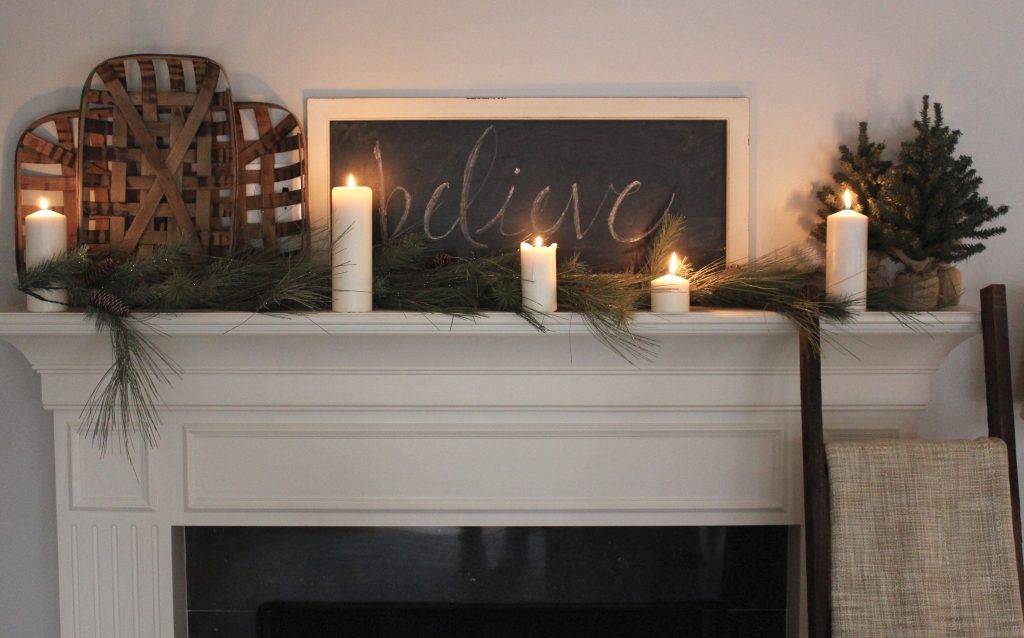 A farmhouse Christmas Mantel dressed in candlelight- home decor- holiday- mantel decor- Do it Yourself- DIY DIY projects- candlelight mantel- living room decorating ideas- room design- rustic home decor- decoration ideas- candlelight and greenery mantel- chalkboard script- winter mantel