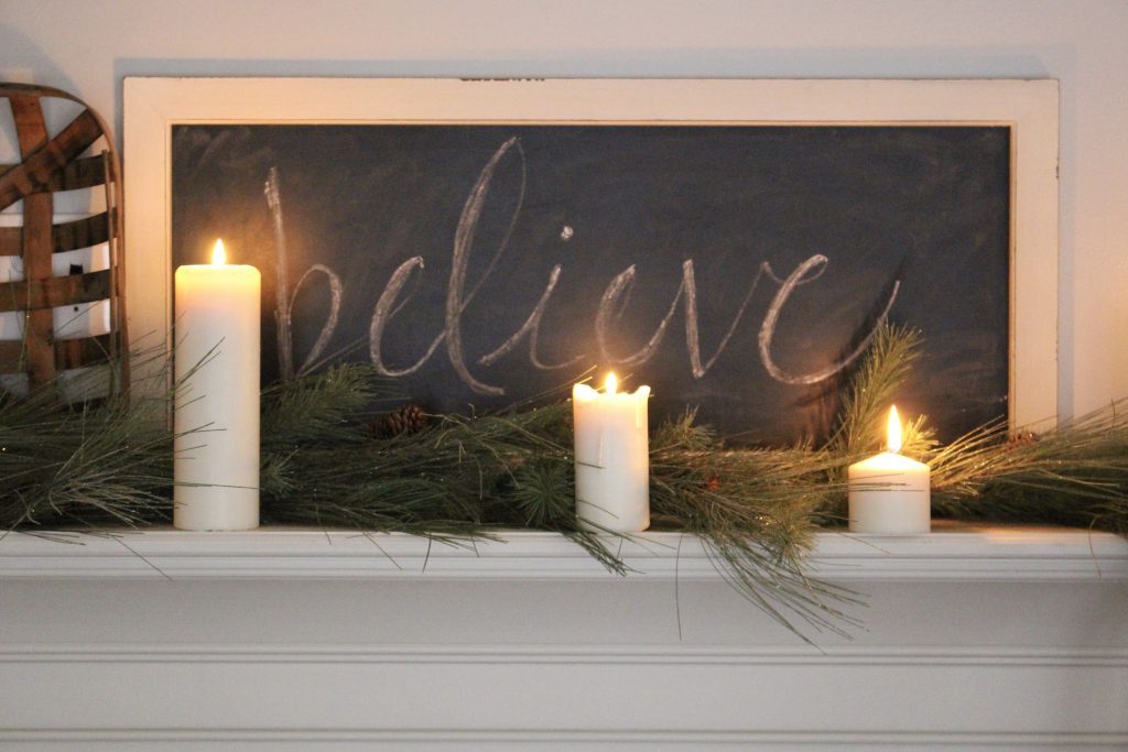 A farmhouse Christmas Mantel dressed in candlelight- home decor- holiday- mantel decor- Do it Yourself- DIY DIY projects- candlelight mantel- living room decorating ideas- room design- rustic home decor- decoration ideas- candlelight and greenery mantel- chalkboard script- winter mantel- candlelight
