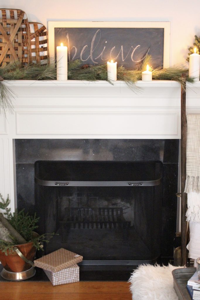 A farmhouse Christmas Mantel dressed in candlelight- home decor- holiday- mantel decor- Do it Yourself- DIY DIY projects- candlelight mantel- living room decorating ideas- room design- rustic home decor- decoration ideas- candlelight and greenery mantel- chalkboard script- winter mantel- candlelight- farmhouse Christmas ideas