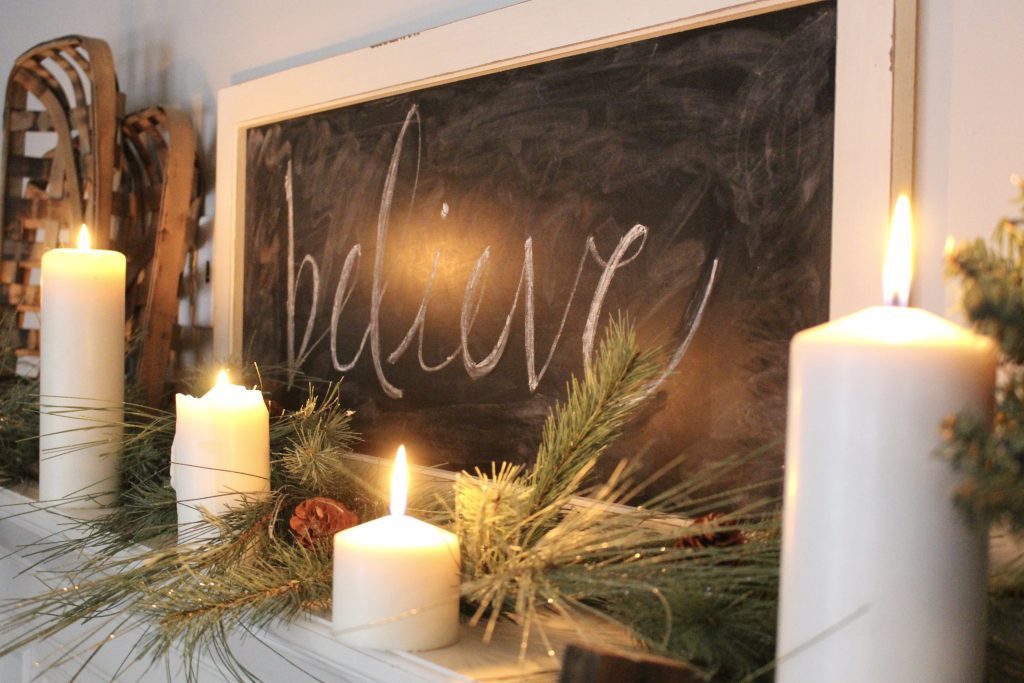 A farmhouse Christmas Mantel dressed in candlelight- home decor- holiday- mantel decor- Do it Yourself- DIY DIY projects- candlelight mantel- living room decorating ideas- room design- rustic home decor- decoration ideas- candlelight and greenery mantel- chalkboard script- winter mantel- candlelight- farmhouse Christmas ideas- decor