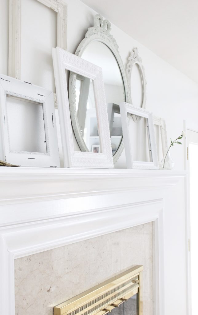 A shabby chic white mantel- layered frames- white mirror- all white decor- romantic design- fireplace decor- mantel decor- home design- decor ideas- mantles- french country style mantel- DIY- Do it Yourself- DIY projects- room design- wall decorating ideas- gallery wall- room decor ideas- decoration ideas- farmhouse style 