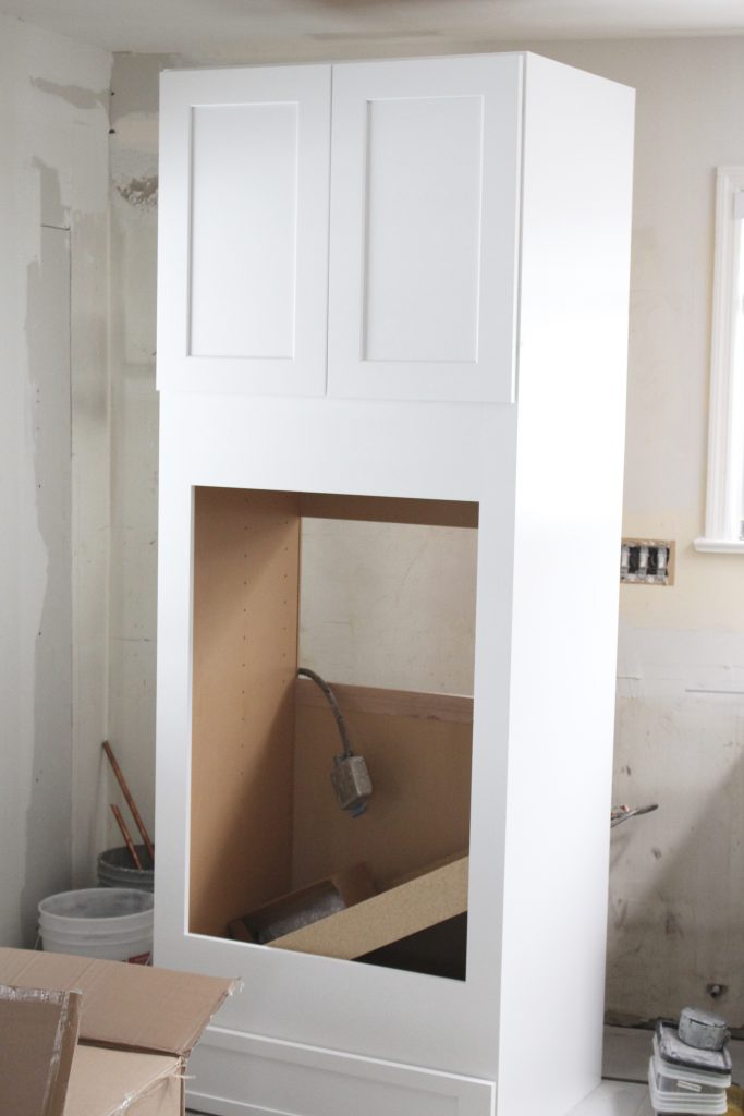 White farmhouse sink installed in new kitchen cabinetry