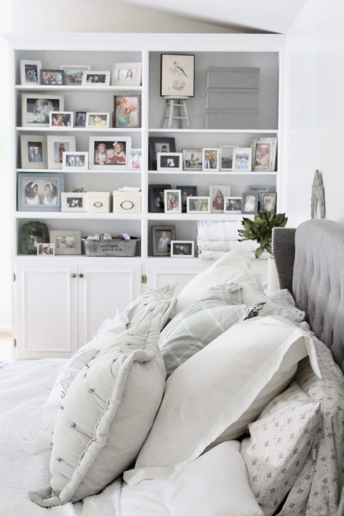 White Cottage Master Bedroom- gray- white- green- shabby chic bedroom- farmhouse decor- layered mirrors- painted gray furniture- DecoArt- Repose Gray- white bedding- white painted furniture- Armoire- fireplace in the bedroom- home design- large bedroom space- sitting area in the bedroom- bookshelves in a bedroom- upholstered bed