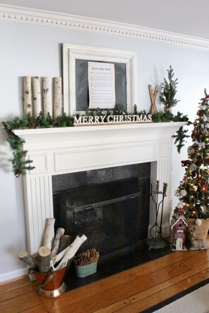 farmhouse rustic Christmas mantel- birch logs- chalkboard- animal ornaments- wicker basket- slim tree- song sheet- mantels- mantles