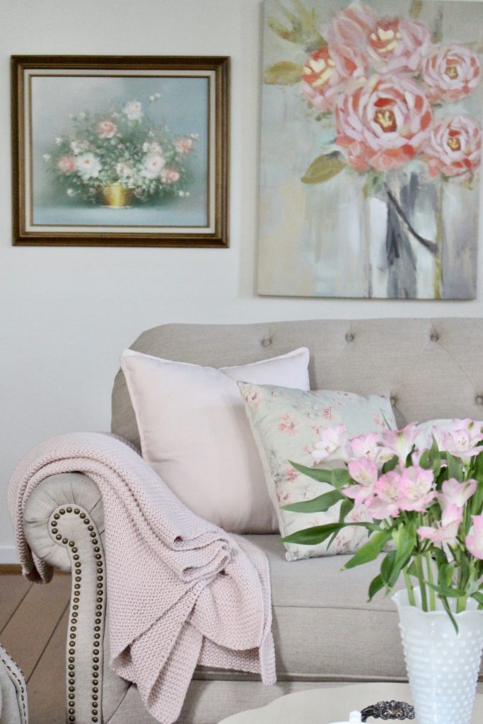 An updated family room space with seasonal spring decor, spring- family room decor- gray washed ceiling- pink decor- gray decor- using pastels in decorating- large family room space- vintage wall art