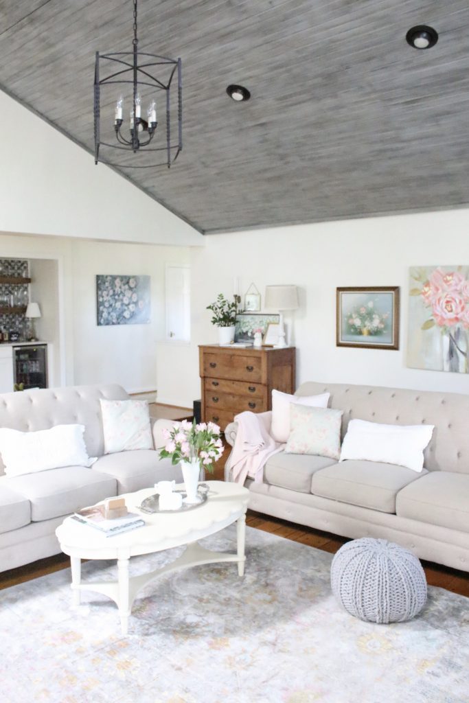 An updated family room space with seasonal spring decor, spring- family room decor- gray washed ceiling- pink decor- gray decor- using pastels in decorating- large family room space- gray ceiling