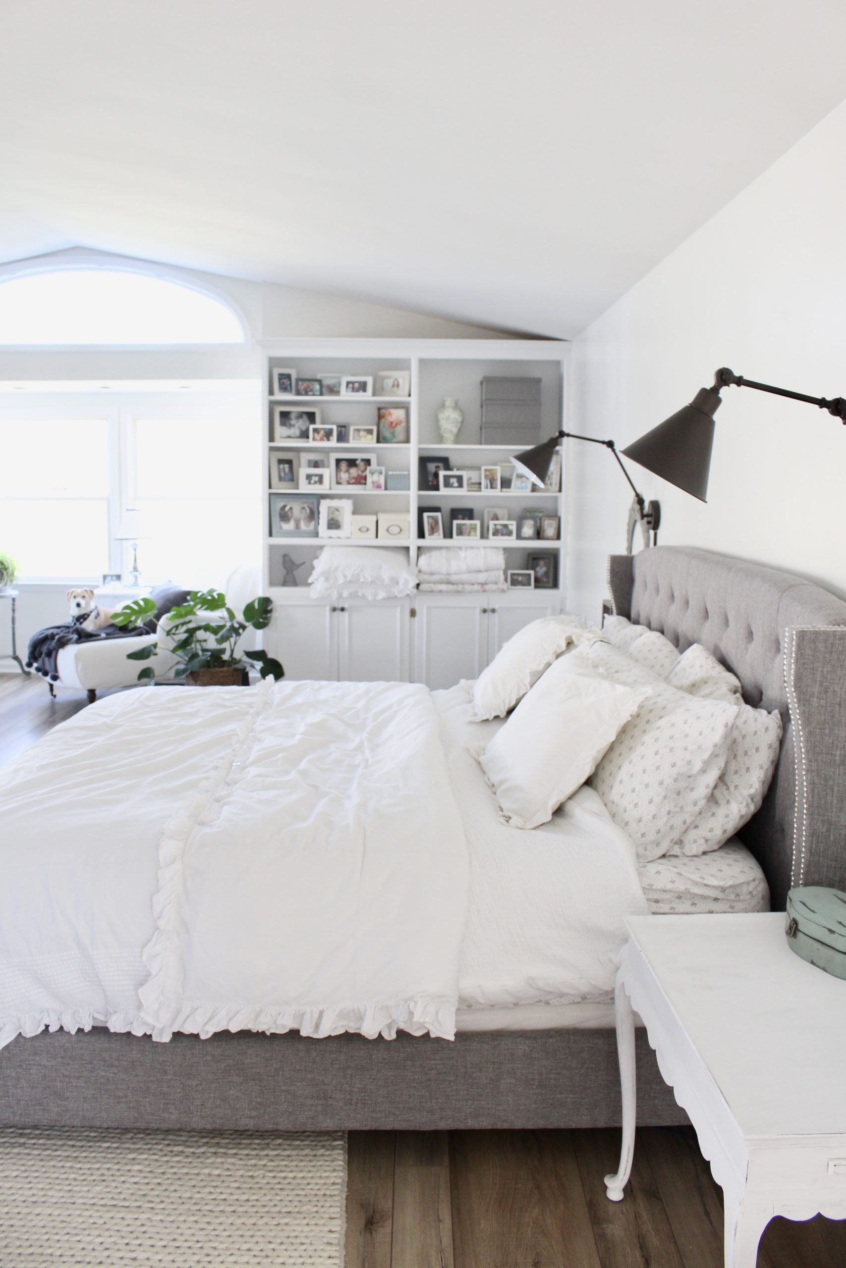 Cozy white master bedroom- An updated space with new flooring and a retiled fireplace