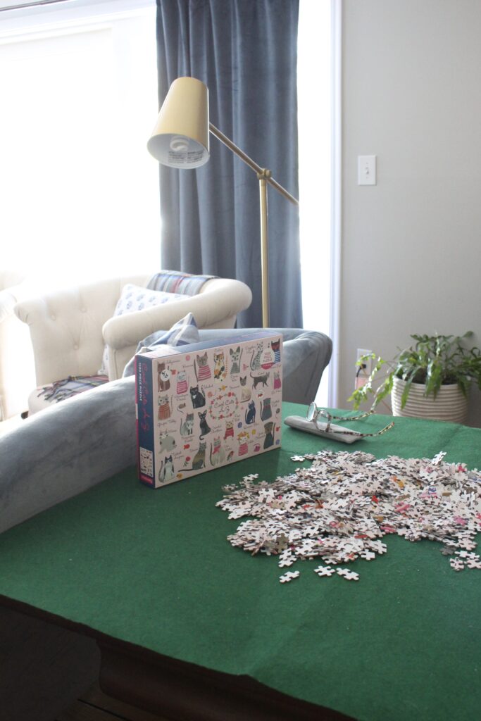 Folding game table with green felt top and jigsaw puzzle in progress in the home library