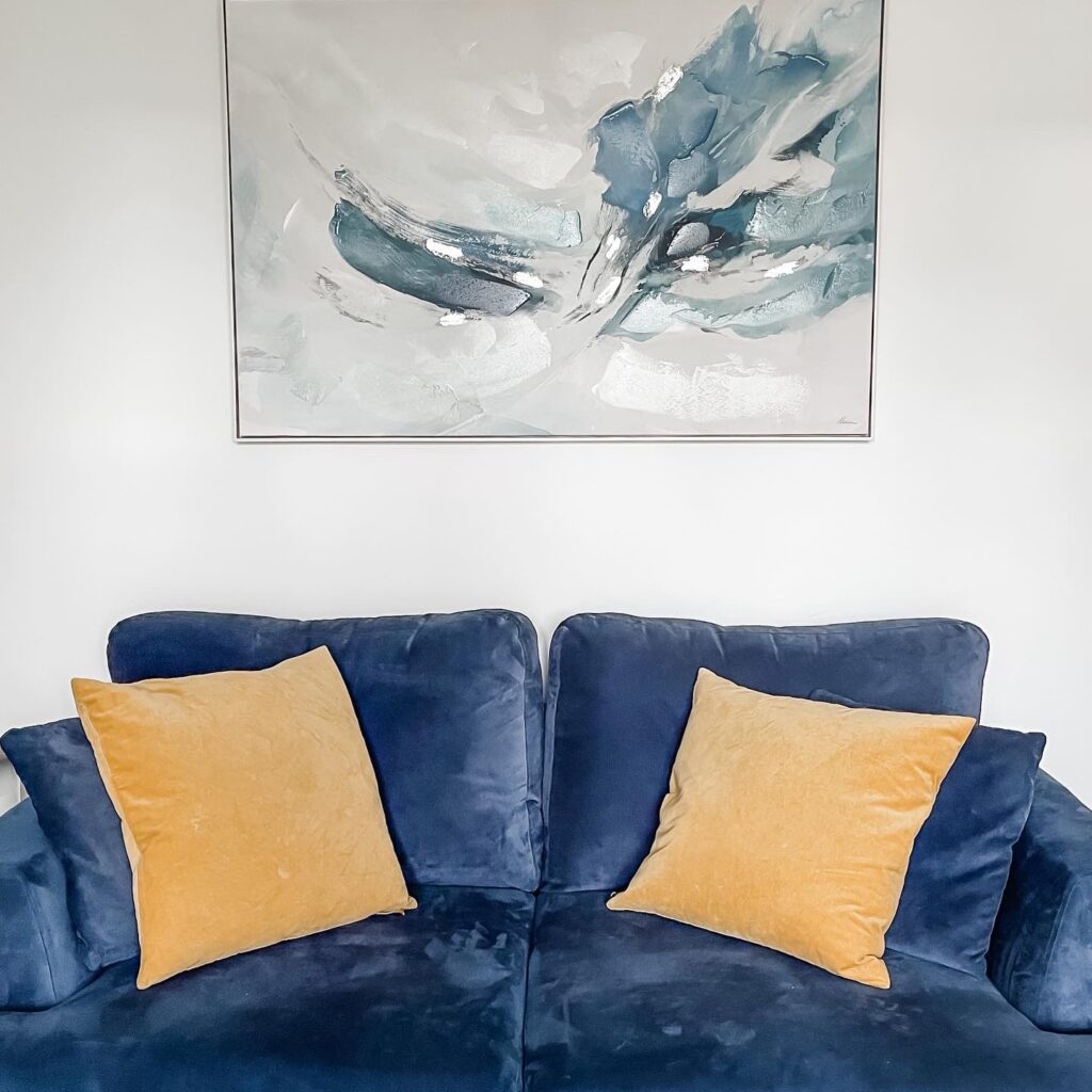 Yellow mustard IKEA cushion covers on a blue sofa