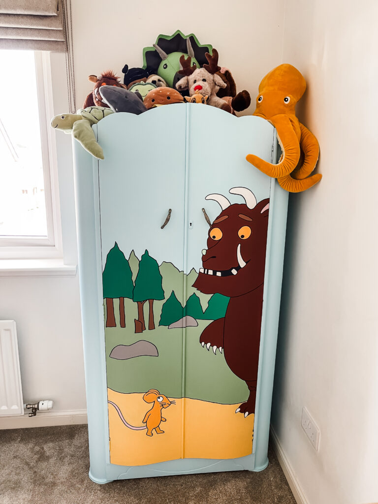 DIY wardrobe makeover with a hand-painted mural in vibrant colors.