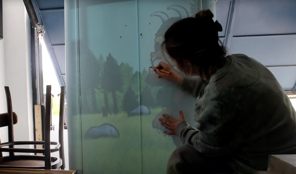 Using a projector to outline the Gruffalo on the wardrobe