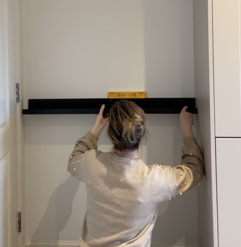 Measuring wall space behind kitchen door for shelf installation and levelling shelves