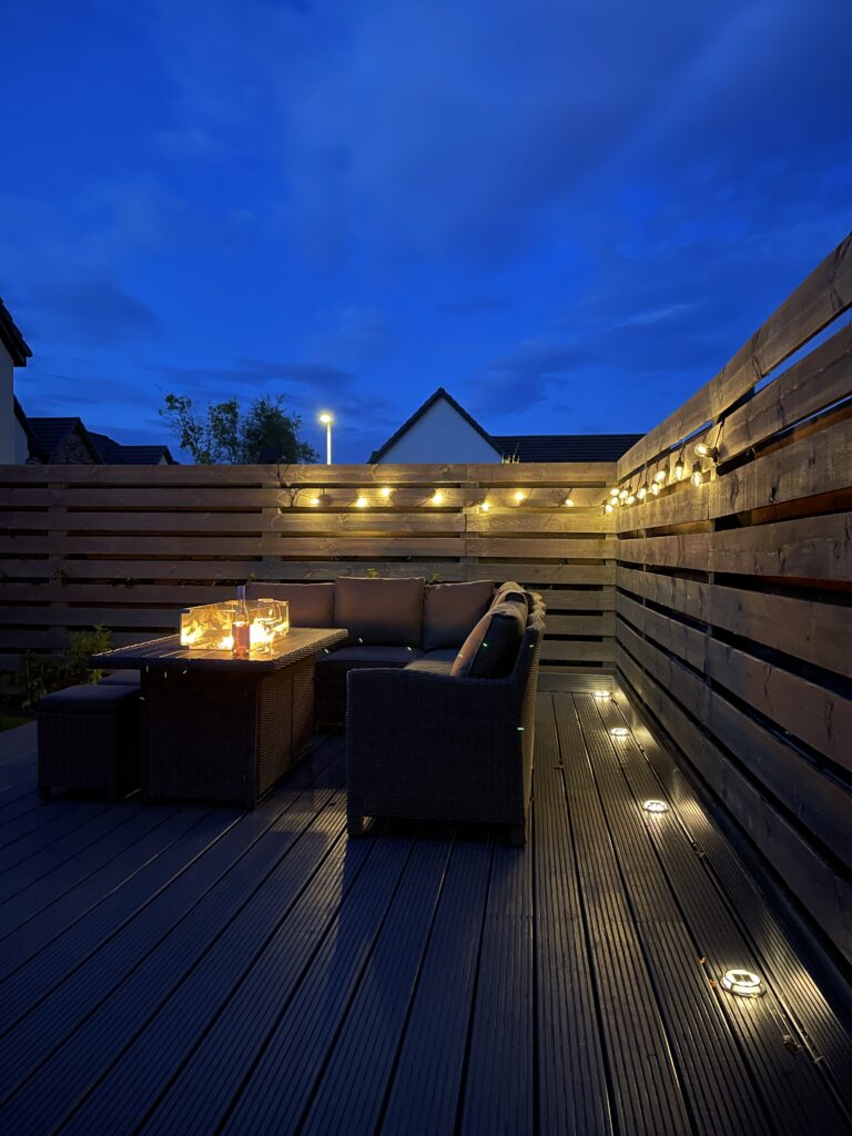 A cozy space with solar powered deck lights and fire pit 