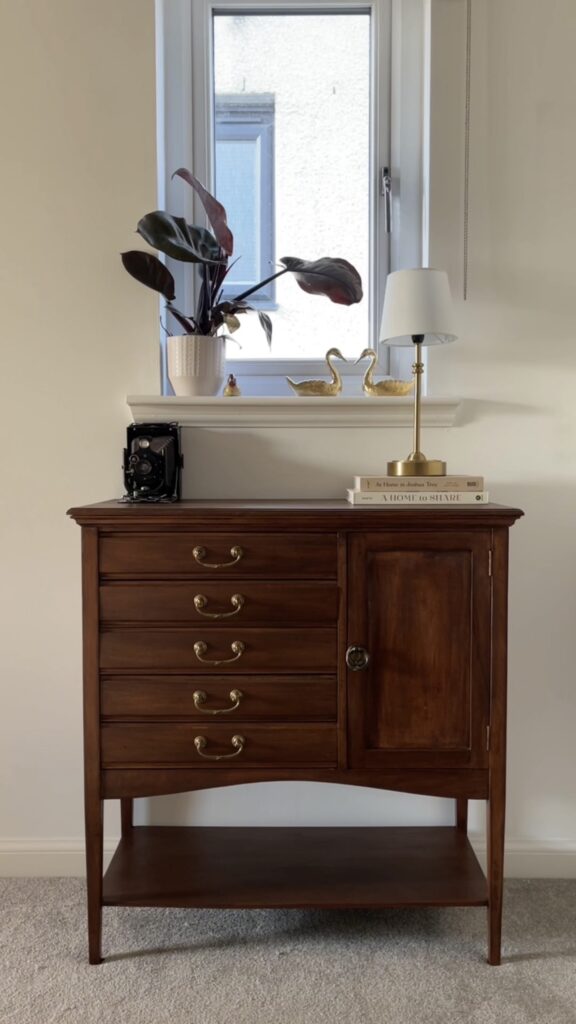 Restored vintage music cabinet styled with modern décor in a living room.