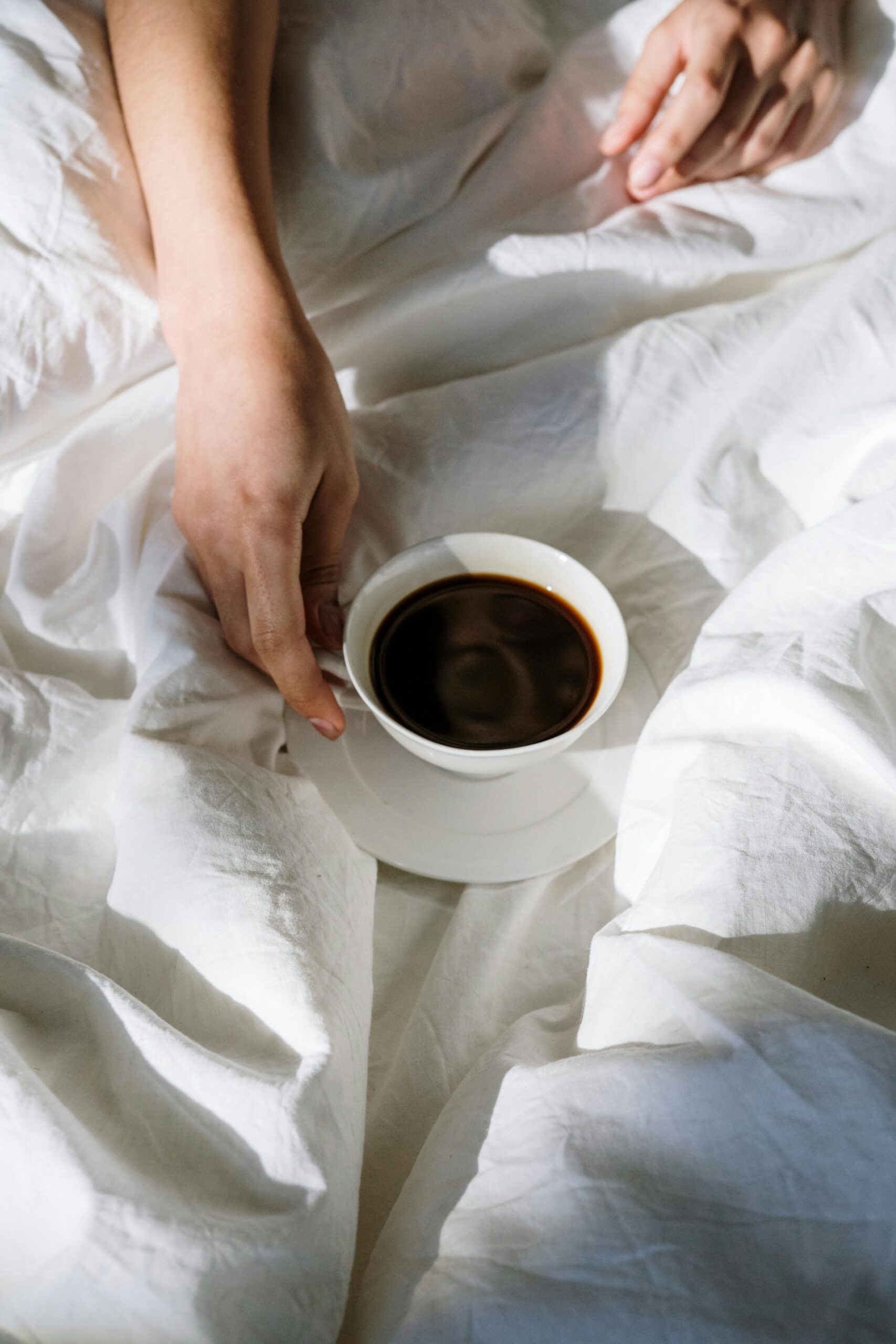 holding onto a homemade coffee in bed