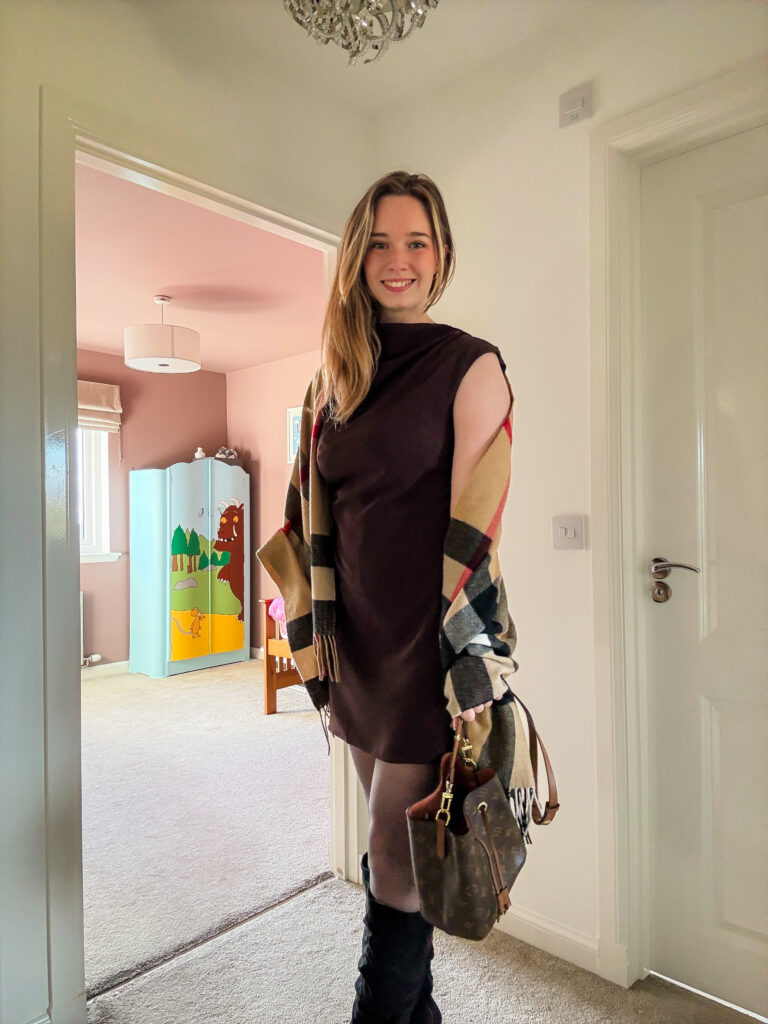 Autumn outfit featuring a brown sleeveless dress with a Burberry scarf and black boots, ideal for a seasonal dinner date.
