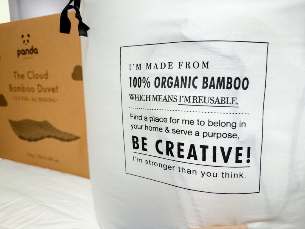 A white reusable fabric storage bag for bamboo bedding with text stating it is made from 100% organic bamboo.