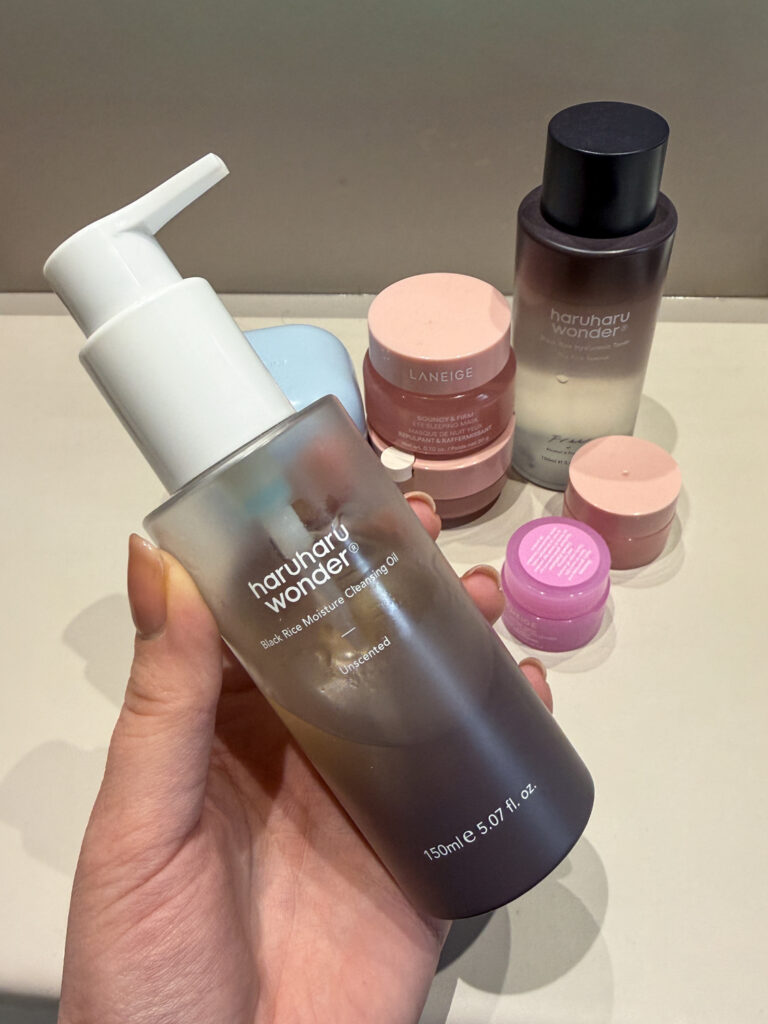 A hand holding the Haruharu Wonder Black Rice Moisture Cleansing Oil, demonstrating the first step of a gentle double cleansing routine for sensitive skin.