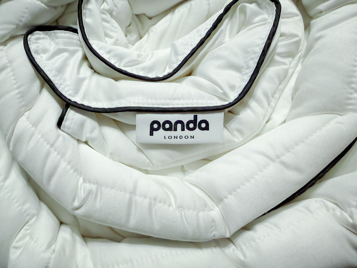 A close-up view of the white Panda London Cloud Bamboo Duvet showing the soft fabric texture and black piping edge.