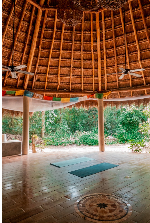 pen-sided yoga and gathering pavilion at Cachito de Cielo Tulum with a high thatched palapa roof, tiled floor, and views into the surrounding jungle