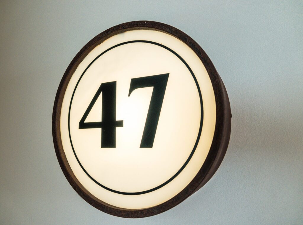 A backlit circular room number sign showing 47 mounted on the wall at Hotel Saul Tel Aviv