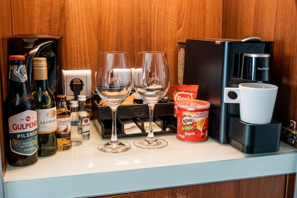 Hotel room minibar at Grand Hotel Amrath Kurhaus with wine glasses, spirits, snacks and a Nespresso machine