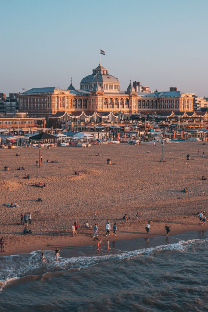 Scheveningen beach at sunset with the Grand Hotel Amrath Kurhaus visible in the distance and the North Sea stretching along the coastline