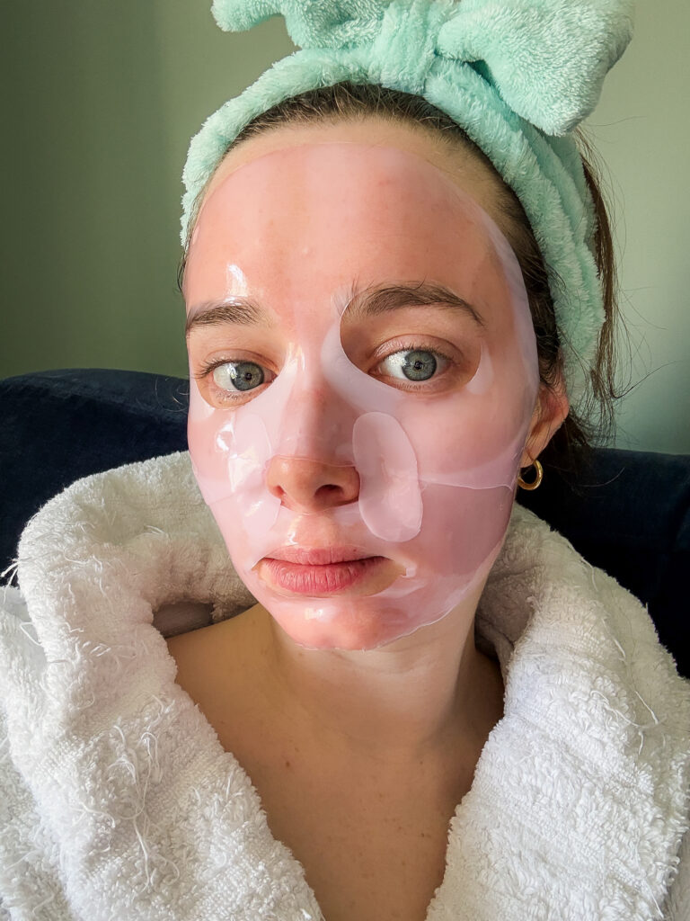 Medicube PDRN pink collagen gel mask mid-transition, showing areas turning clear as skin absorbs the formula