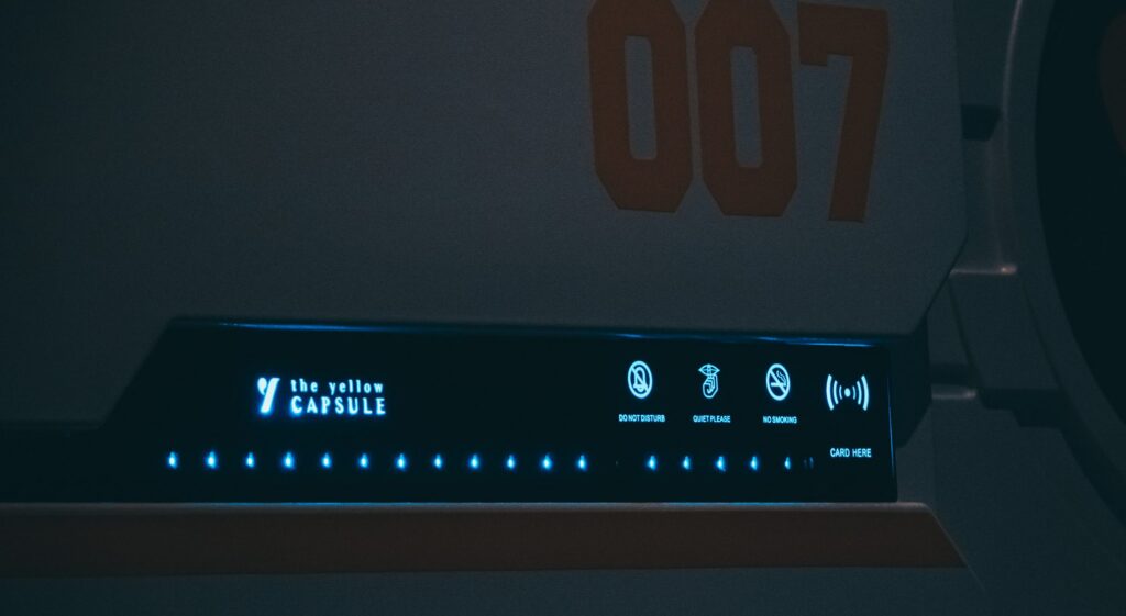The Yellow Capsule hotel illuminated pod display panel showing do not disturb, quiet and no smoking icons