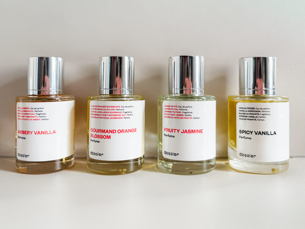 Close-up of Dossier fragrance bottles showing minimalist labels for Ambery Vanilla and Fruity Jasmine, popular affordable perfume alternatives.