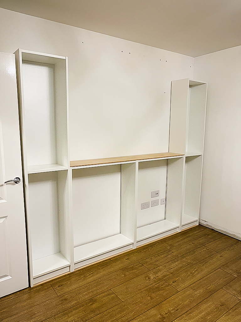 Ikea billy bookcases positioned on timber base showing layout before securing