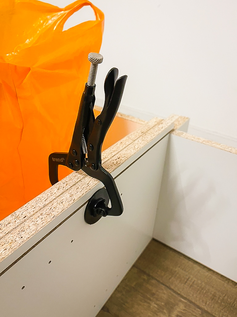 clamp holding billy bookcase units together during media wall assembly