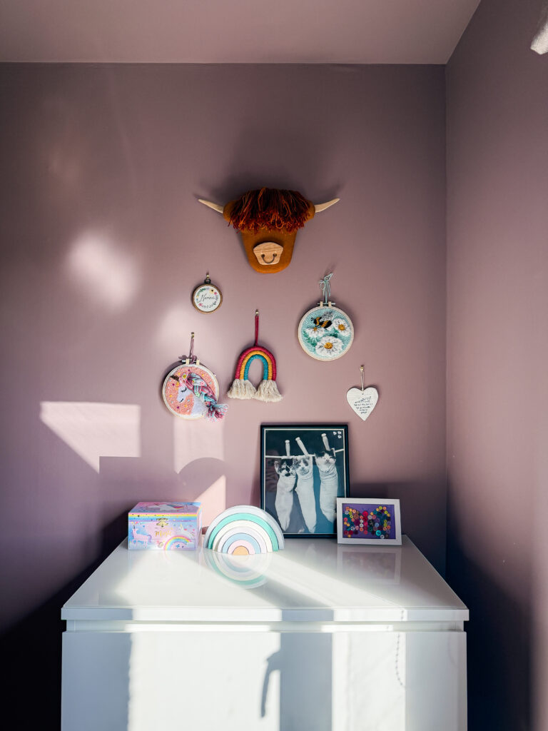 farrow and ball sulking room pink walls with embroidery hoop gallery wall and white chest of drawers in a girl's bedroom