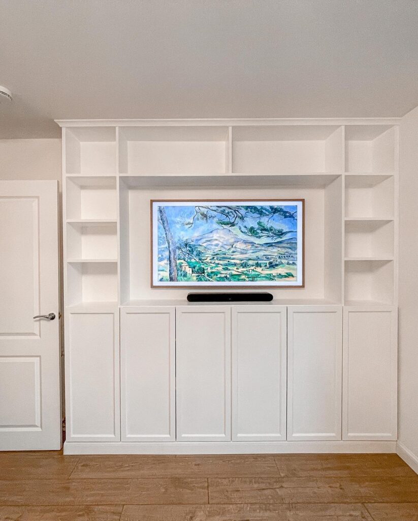 completed ikea billy bookcase media wall from the front with tv mounted and oxberg doors