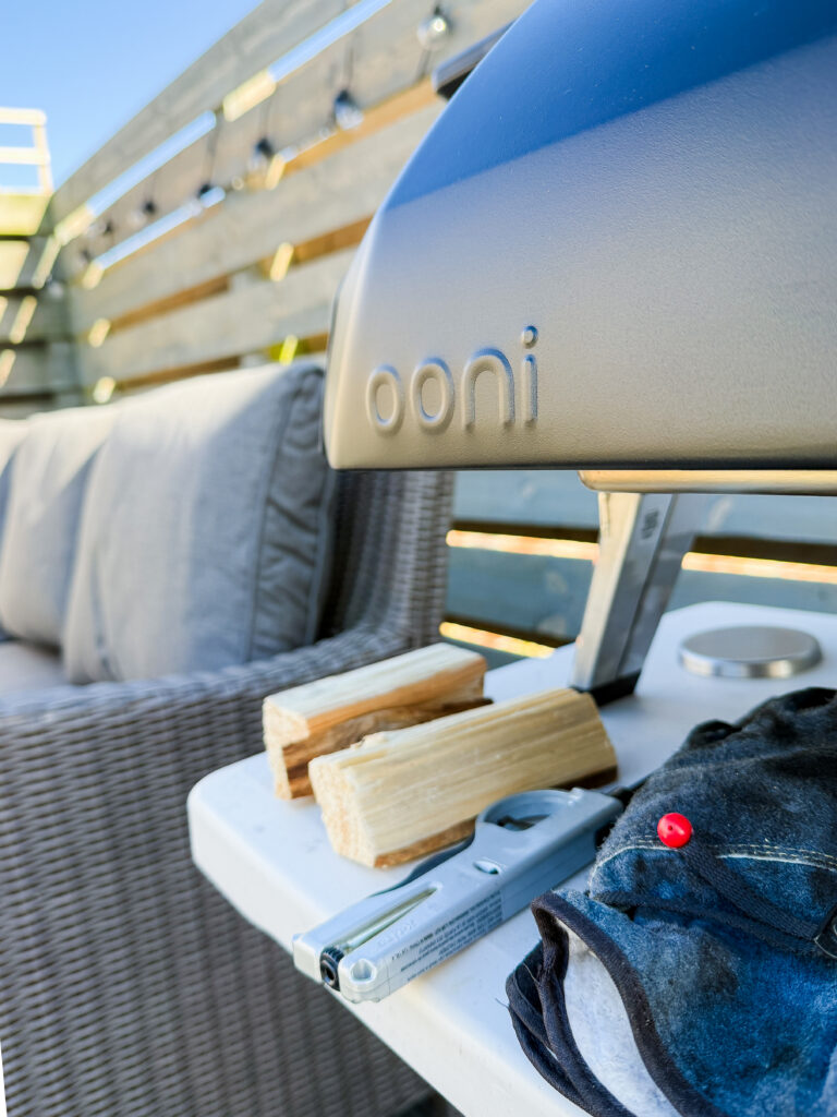 Close up of the Ooni Karu 2 logo on the oven body with wood kindling and a lighter ready for a multi-fuel cook.