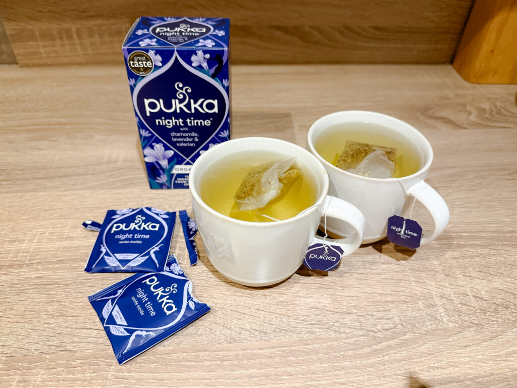 Brewed Pukka Night Time tea in two mugs with the box and loose teabag sachets