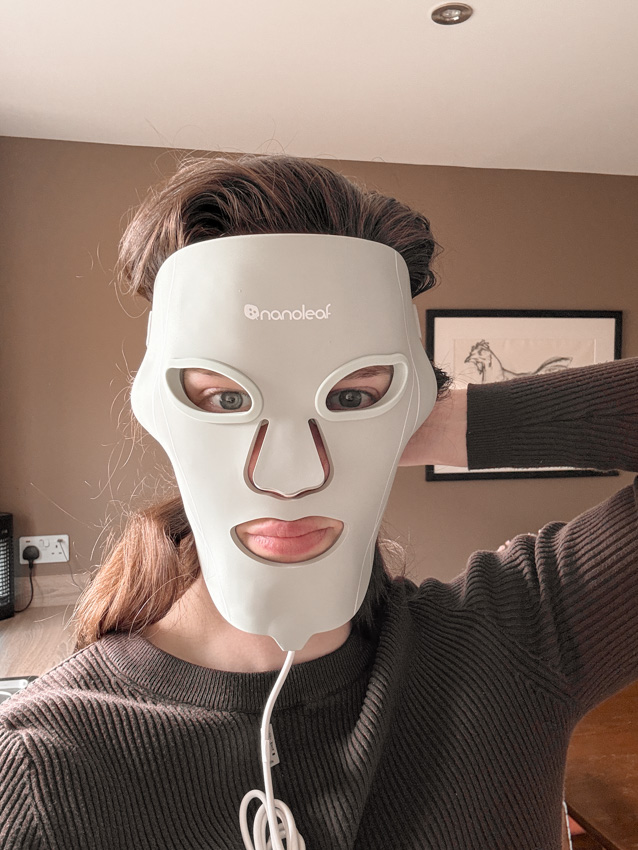 wearing the nanoleaf led mask with eye inserts, holding it up as it's slipping down