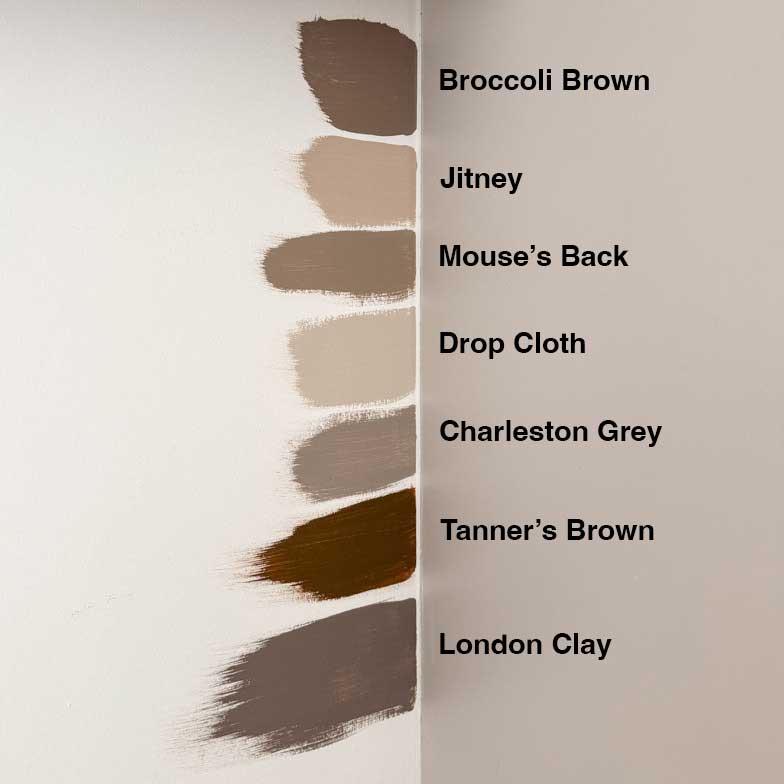 Farrow and Ball samples on the wall next to the purple-beige cabinet. Broccoli brown, Jitney, Mouse's Back, Drop Cloth, Charleston Grey, Tanner's Brown, London Clay.