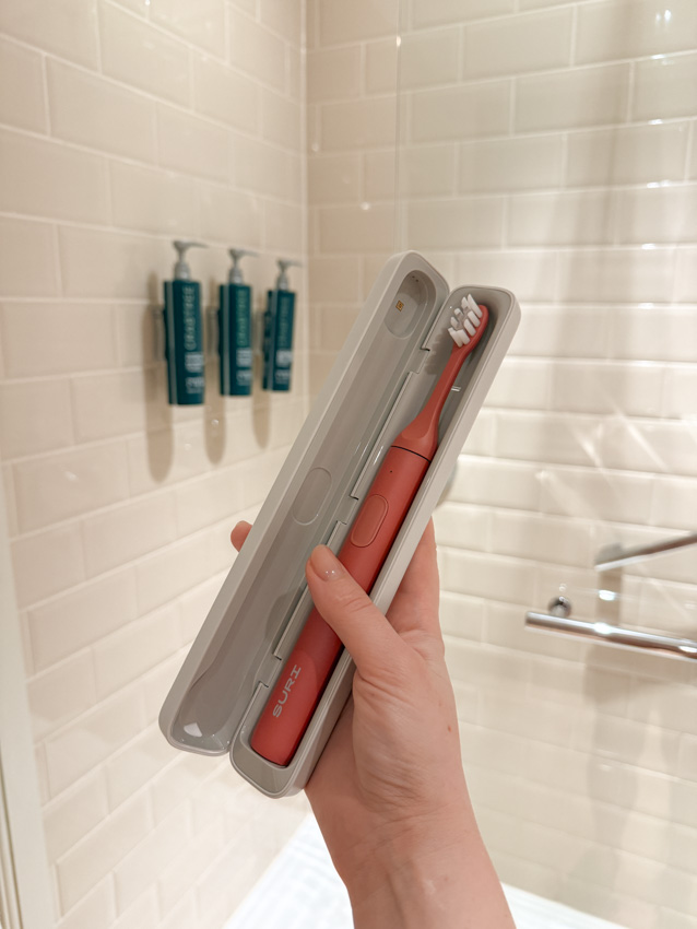 SURI toothbrush in travel case in a Hilton hotel bathroom