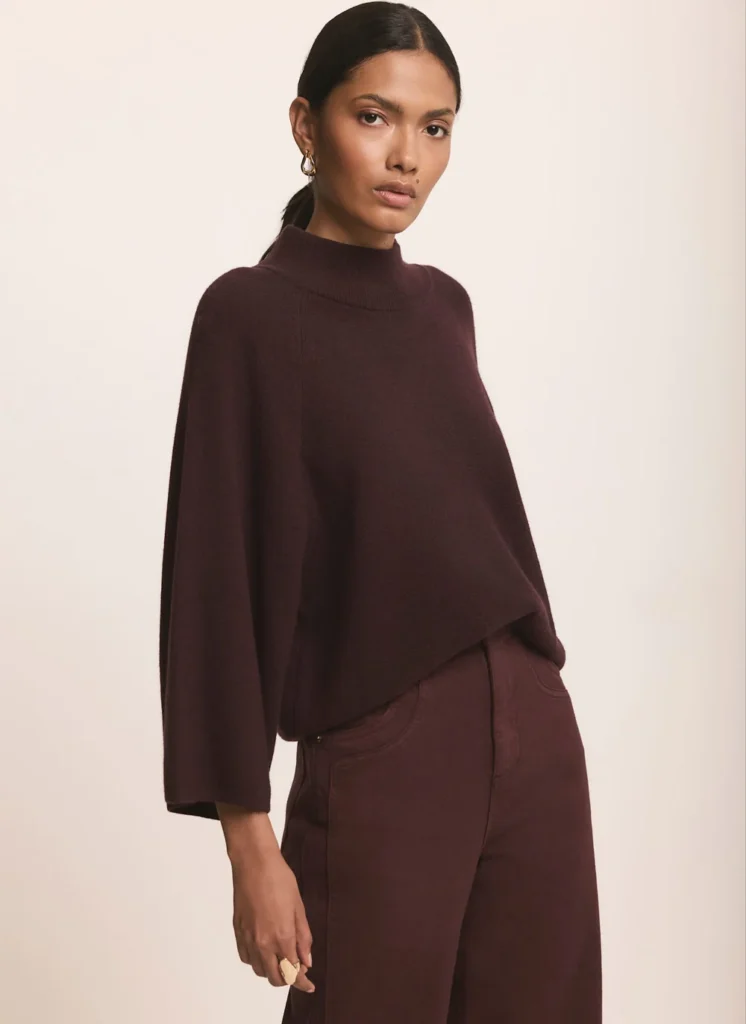 Model wearing the Mint Velvet burgundy wide-sleeve high-neck knit top