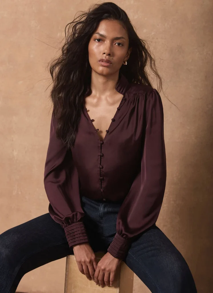 Model wearing the Mint Velvet burgundy satin long-sleeve blouse