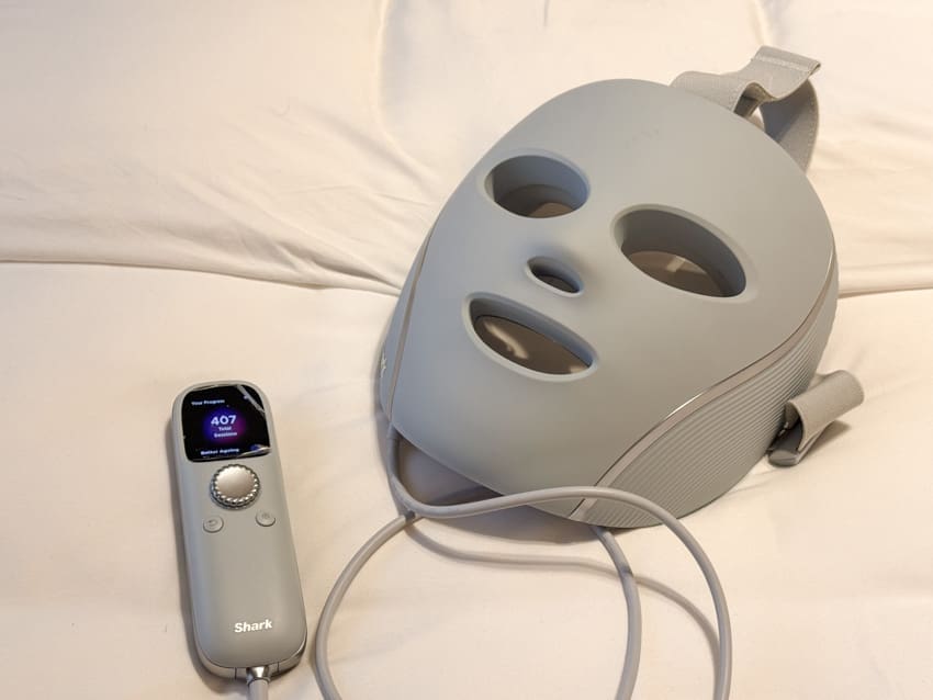 Grey Shark CryoGlow LED face mask and wired controller on white bedding, with 407 total sessions on the screen.