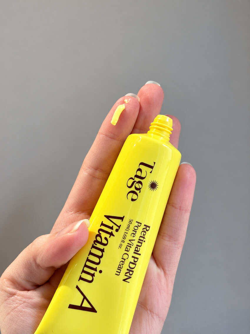Hand holding the Tage Vita A Retinal PDRN Pore Vita Cream tube upright against a neutral background